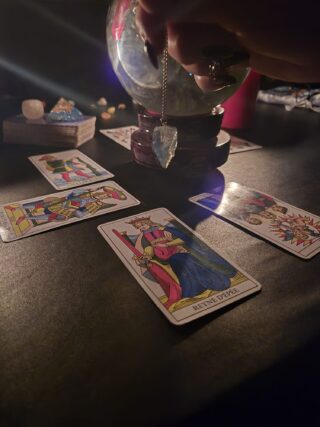 Cartomanzia intuitiva con pendolo, tarocchi e palla magica in rituale energetico